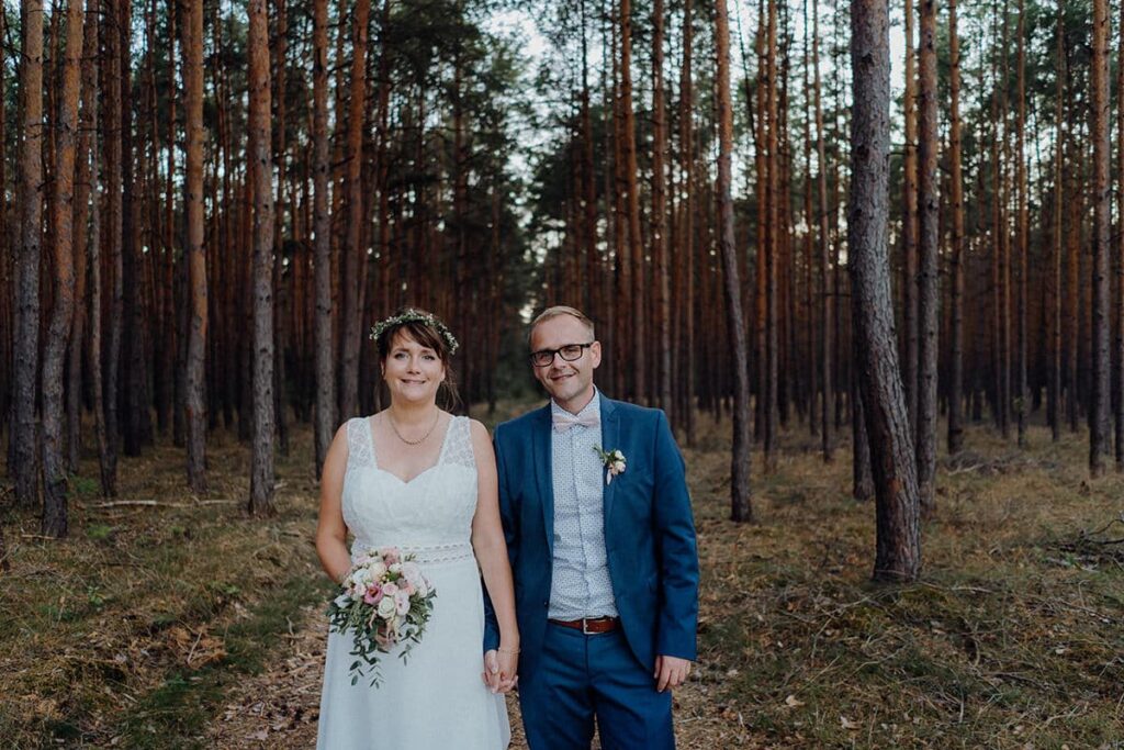 Hochzeitspaar steht im Wald